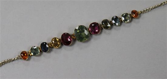 An early 20th century yellow metal and graduated multi gem set bracelet. 16.5cm.